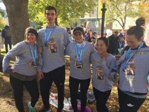 Five tax professionals with medals after running a marathon